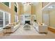 Grand living room with soaring ceilings, large windows, a marble fireplace, and elegant white furniture at 4567 Brigade Ne Ct, Roswell, GA 30075