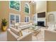 A bright living room with a fireplace, built-in shelving, and large windows at 4567 Brigade Ne Ct, Roswell, GA 30075