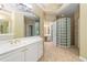 Well-lit bathroom with a glass block shower, double sinks, and tile floors at 4567 Brigade Ne Ct, Roswell, GA 30075