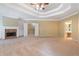 Spacious main bedroom with a fireplace, custom built-ins, and a tray ceiling at 4567 Brigade Ne Ct, Roswell, GA 30075