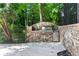 Custom stone outdoor kitchen featuring a built-in grill and stainless steel mini-fridge at 4567 Brigade Ne Ct, Roswell, GA 30075