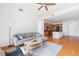 Spacious living room featuring a comfortable sofa, ceiling fan, and view into the modern kitchen at 711 Cosmopolitan Ne Dr # 300, Atlanta, GA 30324