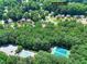 Aerial view of a neighborhood featuring a community pool, tennis courts, and tree-lined streets at 1935 Shrader Ct, Lawrenceville, GA 30044