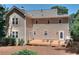 Back exterior elevation featuring a deck with outdoor seating, overlooking the lawn and landscaping at 1935 Shrader Ct, Lawrenceville, GA 30044