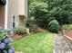 Green backyard featuring manicured lawn, flower bed and brick retaining wall at 1935 Shrader Ct, Lawrenceville, GA 30044