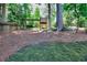 Large, wooded backyard with mature trees and a playset, enclosed by a wood fence at 1935 Shrader Ct, Lawrenceville, GA 30044