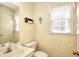 Charming half bathroom with tasteful wallpaper and a traditional vanity at 1935 Shrader Ct, Lawrenceville, GA 30044