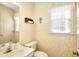 Cozy half-bathroom with patterned wallpaper, a window, and a white vanity at 1935 Shrader Ct, Lawrenceville, GA 30044
