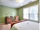 Bedroom featuring green walls, carpet, and a large window with blinds providing ample natural light at 1935 Shrader Ct, Lawrenceville, GA 30044