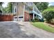 Back exterior of home showing driveway, 2-car garage, and stairs leading to porch above at 1935 Shrader Ct, Lawrenceville, GA 30044