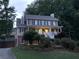 Two-story home featuring green shutters and a welcoming front porch, set against a backdrop of lush trees at 1935 Shrader Ct, Lawrenceville, GA 30044