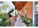 Brick house exterior featuring an outdoor staircase, covered pathway, and lush landscaping at 1935 Shrader Ct, Lawrenceville, GA 30044