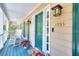 Inviting front porch with rocking chairs and teal-painted floor, leading to a teal front door with sidelights at 1935 Shrader Ct, Lawrenceville, GA 30044