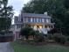 Two-story home with a welcoming front porch, lush landscaping, and a driveway leading to the side of the house at 1935 Shrader Ct, Lawrenceville, GA 30044