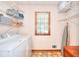 Functional laundry room with washer, dryer, storage shelves, and a window for natural light at 1935 Shrader Ct, Lawrenceville, GA 30044