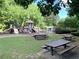 Community playground with picnic tables, climbing structures, and slides near a fenced-in pool at 1935 Shrader Ct, Lawrenceville, GA 30044