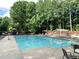 Community pool with lounge chairs and picnic areas surrounded by mature trees at 1935 Shrader Ct, Lawrenceville, GA 30044