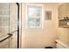 Tiled shower with glass door, window, and bronze fixtures at 1935 Shrader Ct, Lawrenceville, GA 30044