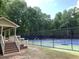 An outdoor tennis court with a shelter and lots of trees surrounding the area at 1935 Shrader Ct, Lawrenceville, GA 30044