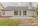 The backyard has a concrete patio, lawn and a beige house at 4565 English Oaks Ln, Lilburn, GA 30047