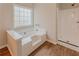 Bright bathroom with a soaking tub, large window and a walk-in shower stall at 4565 English Oaks Ln, Lilburn, GA 30047