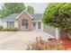 Traditional home featuring brick and siding, a manicured lawn with flower beds, and an attached two-car garage at 4565 English Oaks Ln, Lilburn, GA 30047