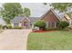Charming home with a well-manicured lawn, mature trees, and a brick facade at 4565 English Oaks Ln, Lilburn, GA 30047