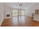 Spacious living area with a cozy fireplace, hardwood floors, and access to the backyard through glass doors at 4565 English Oaks Ln, Lilburn, GA 30047