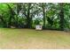 A spacious backyard features a storage shed and mature trees at 551 Barnes Mill Dr, Marietta, GA 30062