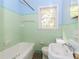 A classic bathroom featuring mint-green tiling with a bathtub and fixtures at 551 Barnes Mill Dr, Marietta, GA 30062