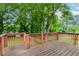 A wooden deck with a red railing overlooks the fenced backyard at 551 Barnes Mill Dr, Marietta, GA 30062
