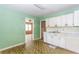 Dated kitchen with green walls, unique flooring, and white cabinetry at 551 Barnes Mill Dr, Marietta, GA 30062