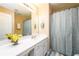 Bathroom featuring a large single sink, mirror, and shower and tub with light neutral color walls at 559 Woodland Park Ter, Lawrenceville, GA 30043