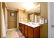 Bathroom featuring double sinks with ample counter space, a large mirror, and neutral colored walls at 559 Woodland Park Ter, Lawrenceville, GA 30043