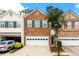 Two story brick townhome with a white garage door and manicured landscaping at 559 Woodland Park Ter, Lawrenceville, GA 30043