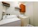 Functional laundry room featuring a washer, dryer, and storage shelves for convenience at 559 Woodland Park Ter, Lawrenceville, GA 30043