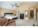 Bedroom featuring a vaulted ceiling, ceiling fan, plush carpet, comfortable chair and a large bed at 559 Woodland Park Ter, Lawrenceville, GA 30043