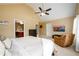 Bedroom featuring a vaulted ceiling, ceiling fan, plush carpet, comfortable chair, TV, and an adjoining bathroom at 559 Woodland Park Ter, Lawrenceville, GA 30043