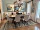 Formal dining room with elegant chandelier, wainscoting, and neutral color scheme at 962 Manor Parc Dr, Decatur, GA 30033