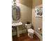 Elegant half bathroom with pedestal sink, decorative mirror, and neutral wall color at 962 Manor Parc Dr, Decatur, GA 30033