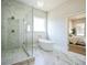 Bright bathroom showcasing a modern tub, glass shower, and marble floors at 1826 Terry Mill Se Rd, Atlanta, GA 30316