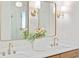 Bright bathroom with double vanity, gold fixtures, quartz countertop and decorative mirror with sconces at 1826 Terry Mill Se Rd, Atlanta, GA 30316