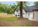 Backyard featuring a well-maintained lawn, mature trees, a grill, and a modern white house at 2263 Barge Rd, Atlanta, GA 30331