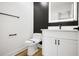 Modern bathroom with a black accent wall and a lighted mirror at 2263 Barge Rd, Atlanta, GA 30331