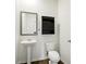 Modern powder room with a pedestal sink, dark wood-look flooring, and a dark cabinet for storage at 2804 Torunn Ct, Atlanta, GA 30331