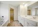 Bright bathroom featuring a double sink vanity, and a doorway to an adjacent walk-in closet at 2804 Torunn Ct, Atlanta, GA 30331