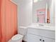 Well lit bathroom features a toilet, sink, and shower with an orange shower curtain at 3360 Meadow Grass Dr, Dacula, GA 30019