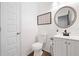 Clean half-bathroom featuring a stylish mirror, wood-look floors and updated fixtures at 3360 Meadow Grass Dr, Dacula, GA 30019