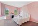 Cozy bedroom with lots of light, a princess canopy bed, and pink walls at 3360 Meadow Grass Dr, Dacula, GA 30019