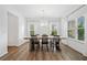 Elegant dining room with modern light fixture, hardwood floors, and large windows offering abundant natural light at 3360 Meadow Grass Dr, Dacula, GA 30019
